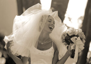 Wedding Photographer Los Angeles at Bel Air Bay Club of bride laughing with bouquet of flowers